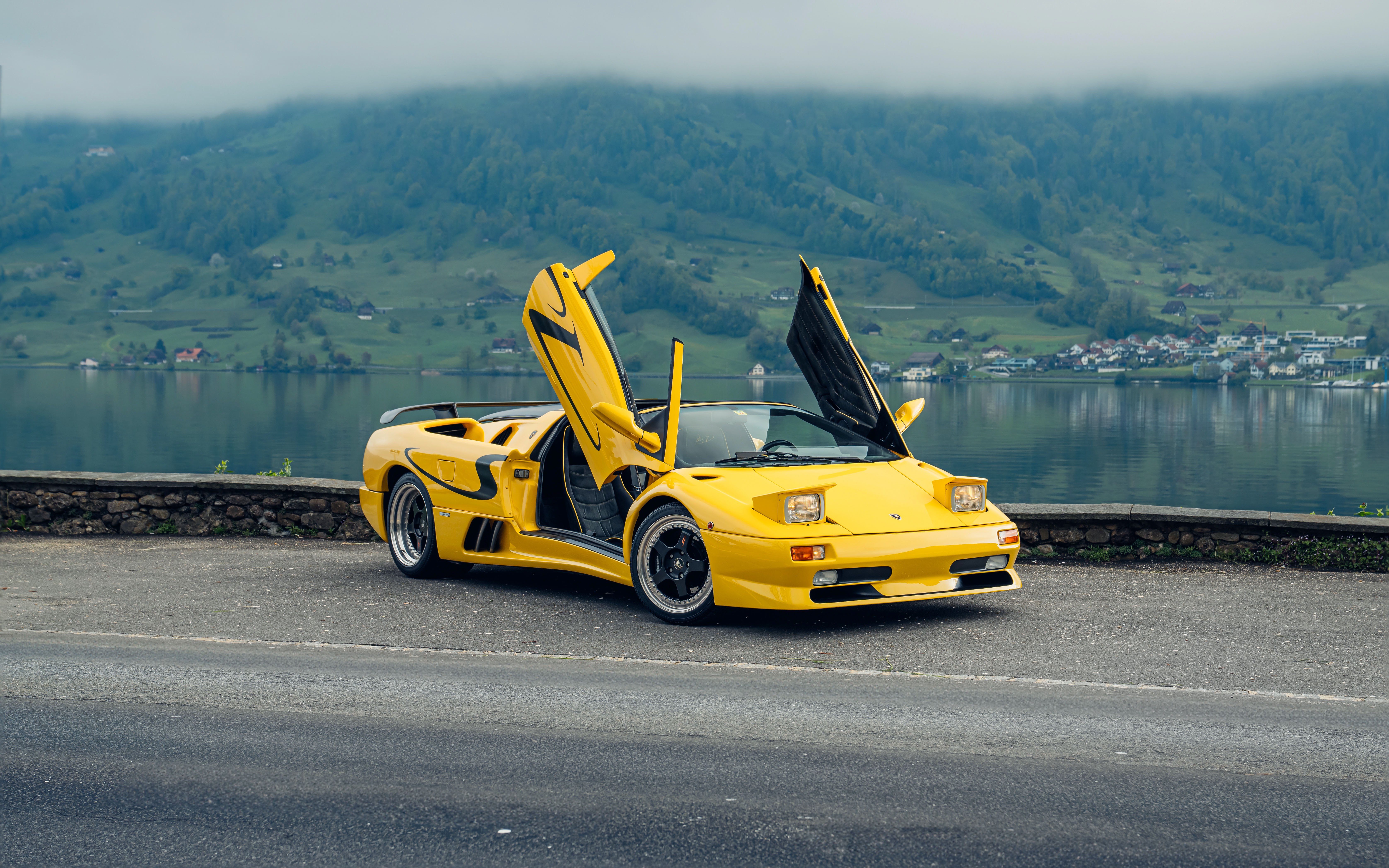 Yellow Lamborghini Diablo with doors open by lake